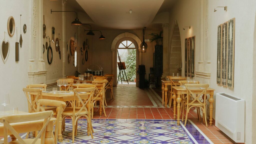 Sala interna del ristorante Taverna Russo a Ortigia con tavoli in legno e pavimento in piastrelle decorate